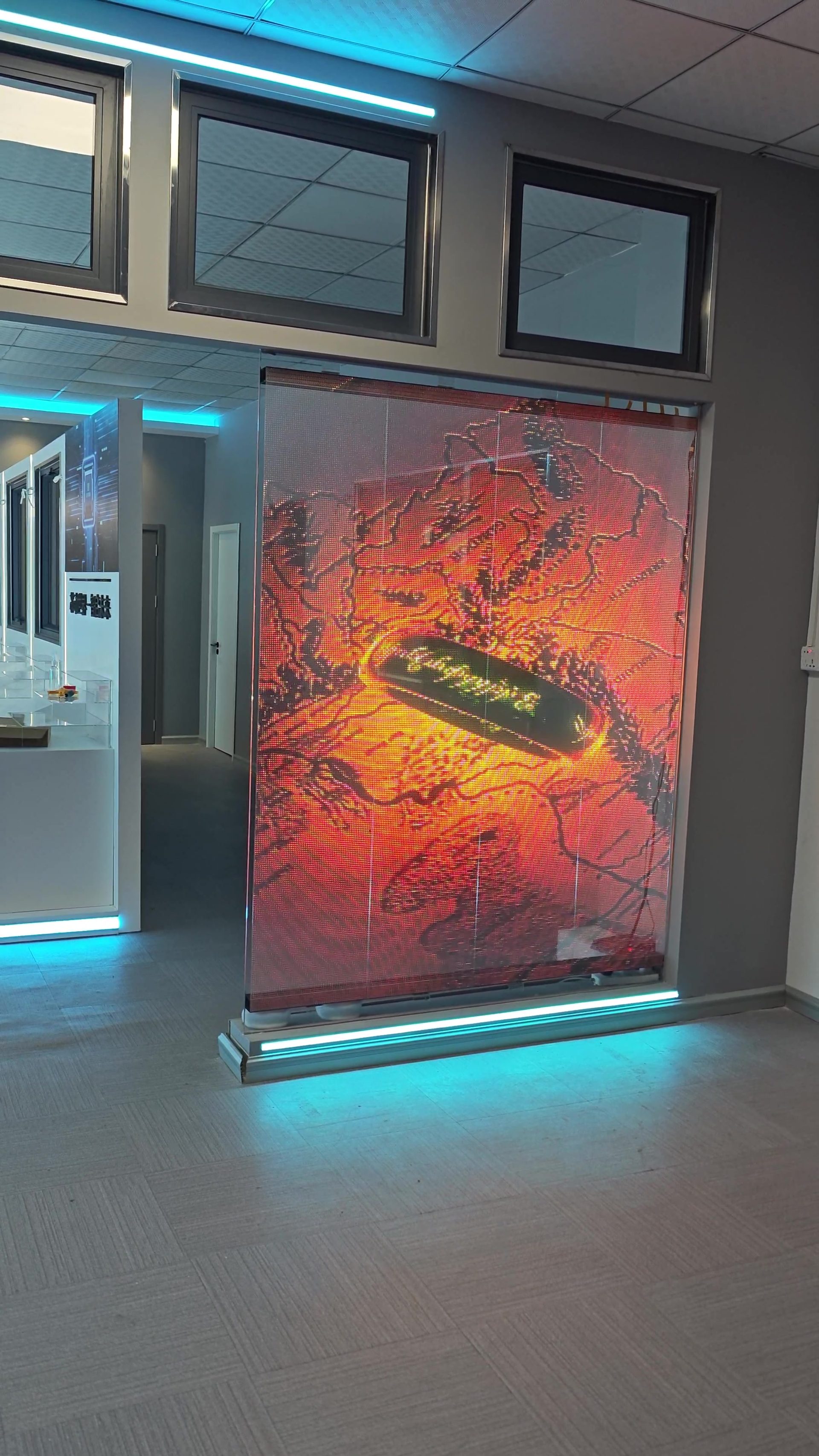 Glass showroom pavilion with transparent LED film on the glazing