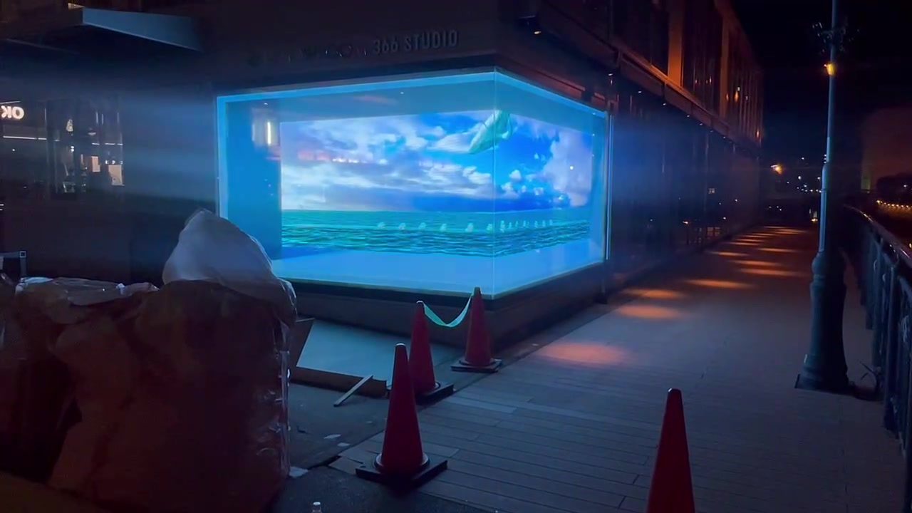 Street-front glass storefront in Japan playing content on Crystal Film LED